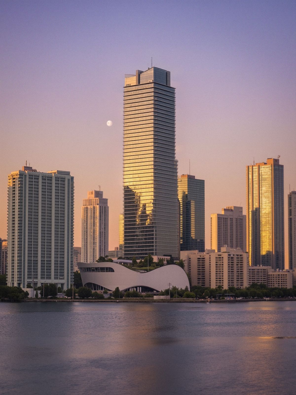 Skyline de cidade litorânea refletido na água ao anoitecer